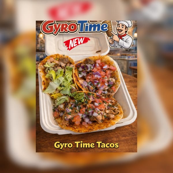Three Gyro Time tacos with various toppings in a white takeout container on a wooden surface.